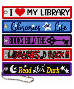 Five rectangular embroidered fabric keychain patches arranged vertically on a white background, each with textured stitching, colorful borders, and a metal grommet. Designs include “I Love My Library” in red and white, “Libraries Are Life” in blue, “Books Hold the Key” with a skeleton key on purple, “Libraries Rock!!” in red and black, and “Read After Dark” with a crescent moon and stars on black and purple. A silver ball chain is attached to the bottom patch.