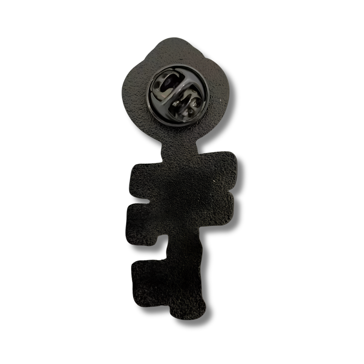 Back view of the Books Hold the Key skeleton key-shaped enamel pin, featuring a textured black metal backing and a circular black butterfly clutch fastener near the top. Shown against a white background.