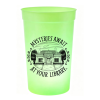 Bright green glow-in-the-dark plastic cup featuring black “Mysteries Await at Your Library” artwork with a public library surrounded by friendly ghosts.