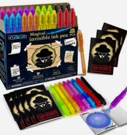 Magical Invisible Ink Pen Set featuring 24 brightly colored pens in a cardboard display box decorated with a secret agent illustration. Includes black “Top Secret” activity cards and a demonstration of hidden writing revealed under ultraviolet light.