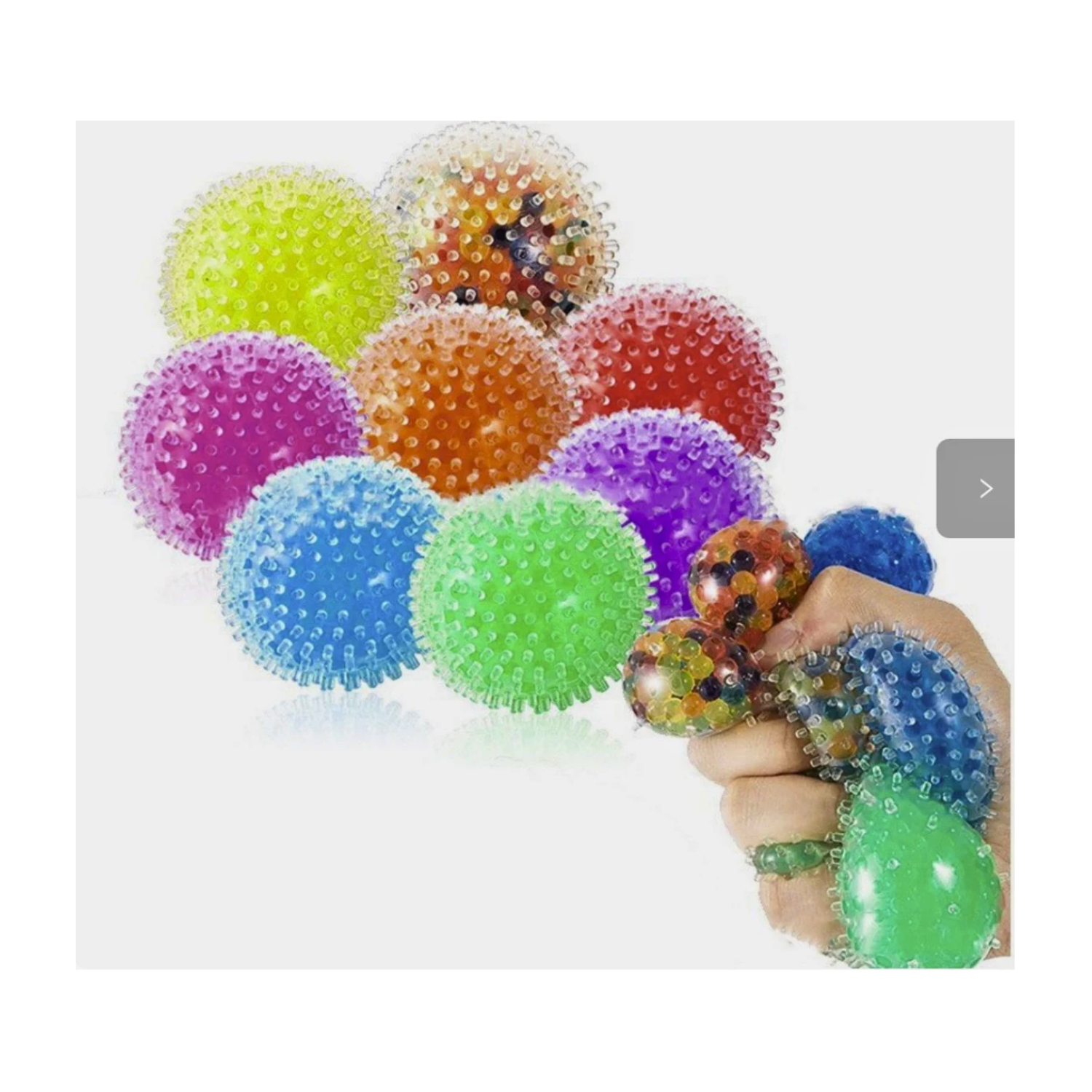 Assortment of colorful, translucent, round sensory fidget balls covered in soft, flexible spikes. Balls are shown in bright green, blue, purple, pink, orange, and red, with a hand squeezing several to demonstrate their squishy texture.