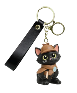 3D Inspector Whiskers keychain featuring a black detective cat with yellow eyes, pink ears, a brown detective hat and cape, and a tiny magnifying glass. Attached to a gold-tone metal clasp with a black wrist strap.